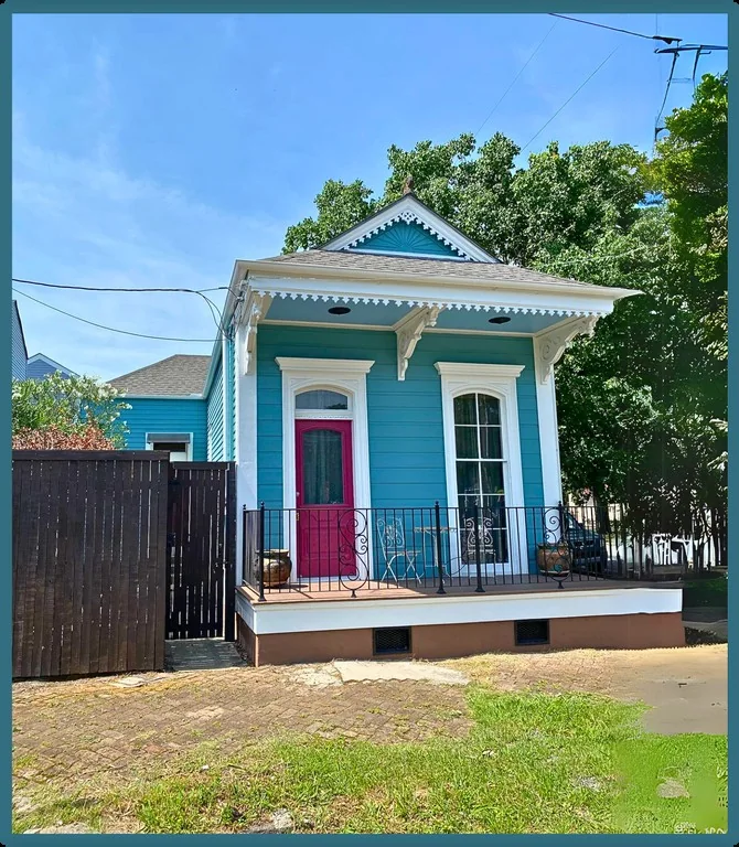 Artsy Cozy Home’s turquoise exterior and bright pink front door