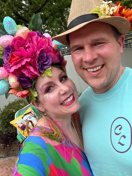 Danielle and Greg in colorful clothes and decorated hats at the Gay Easter Parade