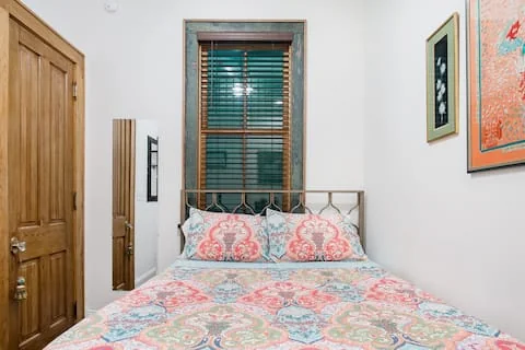 In-law suite bedroom with floral bedding and a window above the bed
