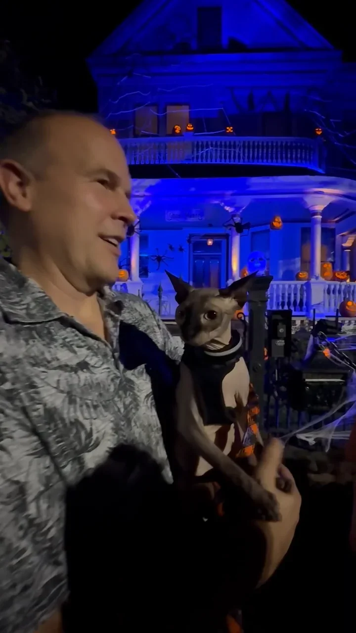 Greg holding Harry in front of a decorated New Orleans home during Halloween season